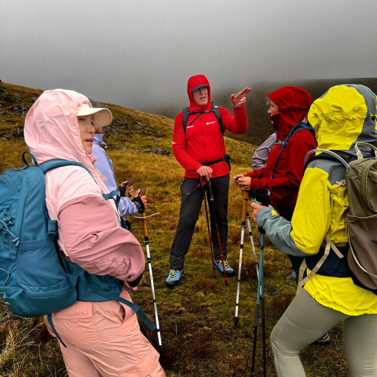 Group of female hikers having a chat with the group instructor. 