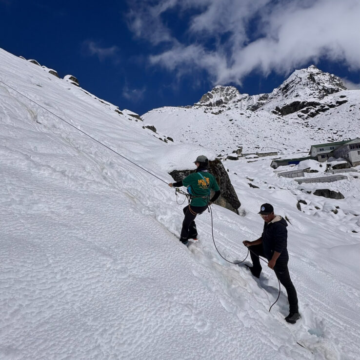 Sherpa guide and climber working together on fixed ropes during Himalayan ascent